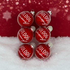 Piros kézzel festett üveg karácsonyi gömb szett „Boldog karácsonyt!” felirattal, havas háttérrel.