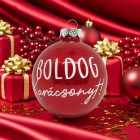 Közelről fotózott piros üveggömb arany ajándékdobozok között, „Boldog karácsonyt!” felirattal.