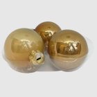 Három aranyszínű üveg karácsonyi gömb egymás mellett.