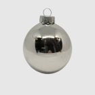 Egy darab fényes ezüstszínű üveg karácsonyi gömb közelről.