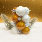 Fehér és arany üveg karácsonyi gömb szett havas háttérben fenyőágakkal (12×6 cm).