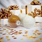 Három darab fehér és arany üveg karácsonyi gömb ajándékdobozok és arany dekorációk mellett (6 cm).