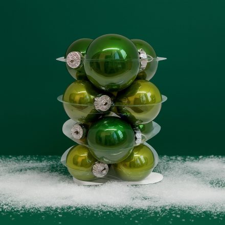 Zöld üveg karácsonyi gömb szett havas dekorációval zöld háttér előtt (12×6 cm).