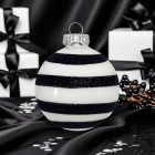 Egy darab Black Glitter Stripe fehér-fekete üveggömb fekete háttér előtt