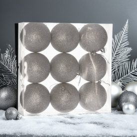 Ezüst glitteres műanyag karácsonyi gömb szett (9×8 cm) átlátszó dobozban, havas felületen, ezüst dekorációval a háttérben.