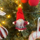 Piros ruhás, kötött sapkás textil Mikulás figura fehér szakállal és fekete övvel, akasztóval.