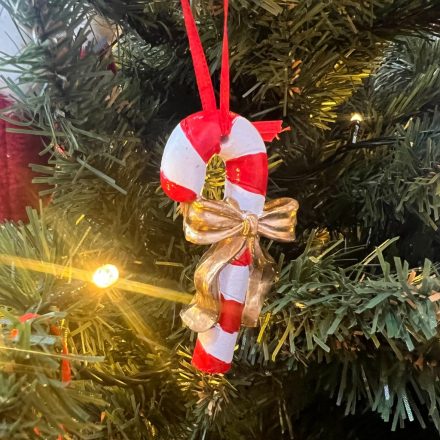 Két piros-fehér csíkos nyalóka arany masnival, piros akasztóval.