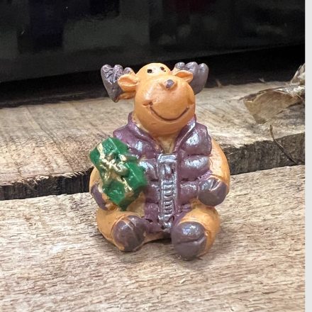 Négy pufi kabátos, ülő rénszarvas figura ajándékkal a kezében