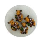 Négy darab pufi kabátos rénszarvas figura kör alakú dobozban, áttetsző fedél alatt.