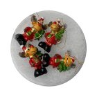 Négy darab rénszarvas figura kör alakú dobozban, piros ruhában, fekete csizmával és zöld fenyővel a kezükben.