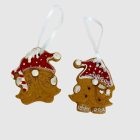 Két mézeskalács-hatású gnóm akasztóval, piros sapkában, fehér háttéren, elölnézet.