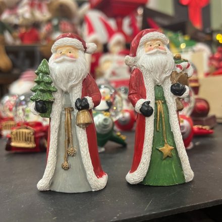 Kétféle Mikulás poly figura karácsonyi háttéren, az egyik karácsonyfával, a másik ajándékzsákkal.